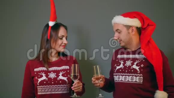 一对戴着圣诞帽的夫妇戴着香槟酒杯庆祝新年视频的预览图
