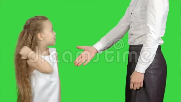 女儿和母亲在绿色屏幕上握手铬键视频的预览图