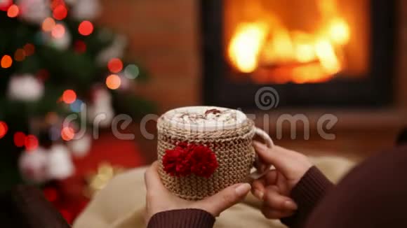 女人的手捧着一杯饮料在圣诞节的时候在摇椅上休息视频的预览图