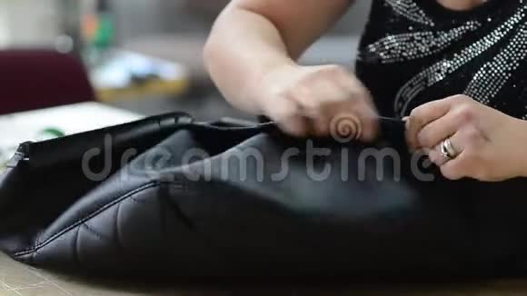 女人用皮革把箱子缝在扶手椅上视频的预览图