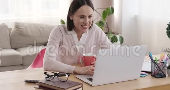 女商人喝咖啡用笔记本电脑视频的预览图