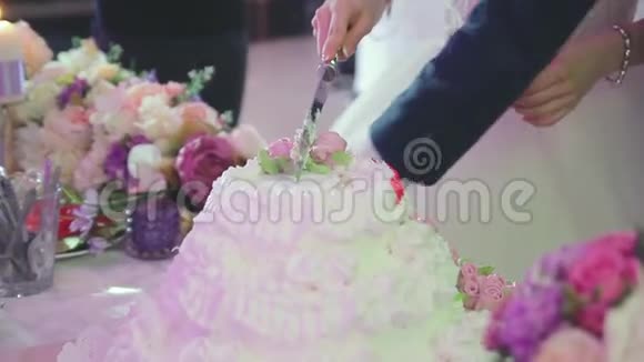 新婚夫妇正在切一块喜庆的大蛋糕视频的预览图
