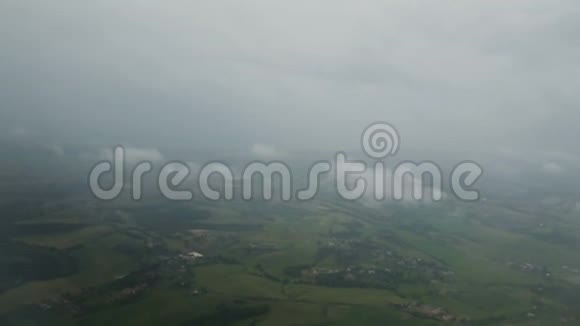 从飞机上看到雾和云在绿色景观上方飞行天气预报视频的预览图