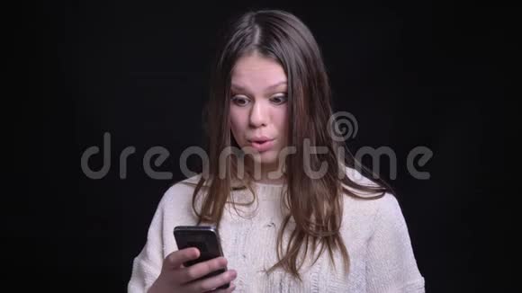 使用电话和在社交媒体的帖子面前回应年轻有魅力的高加索女性的特写照片视频的预览图