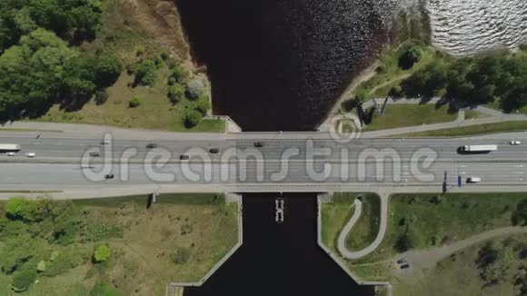 里加市公路桥梁高架桥并在水附近修建公路和汽车交通无人机飞行视频的预览图