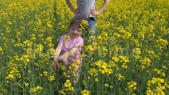 一个孩子正在黄色的草地上玩耍在户外有孩子的女人小女孩和她妈妈在一片田野上视频的预览图