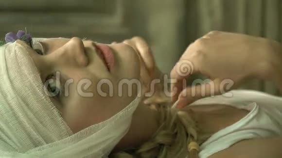 一个戴着绷带的女人躺着抚摸自己视频的预览图
