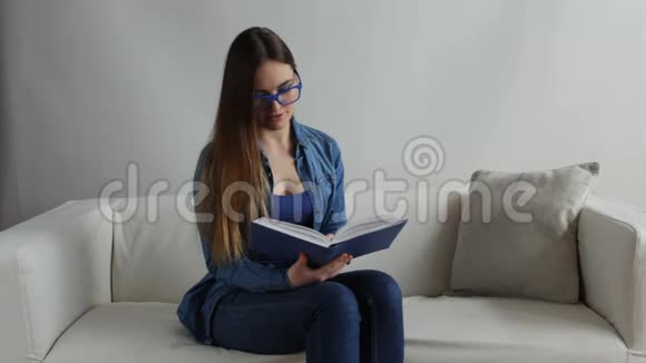 坐在家里沙发看书的女人全高清视频的预览图