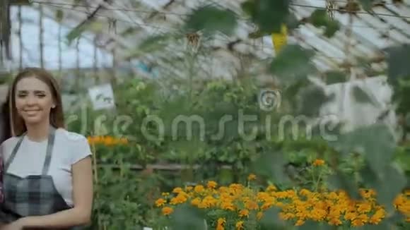 潘文石拍摄了一对年轻的微笑博主一对穿着围裙的园丁手捧鲜花在网上聊天录制视频博客视频的预览图