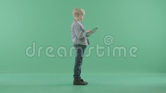 站在绿色屏幕上的男孩拿着他的战术平板电脑视频的预览图