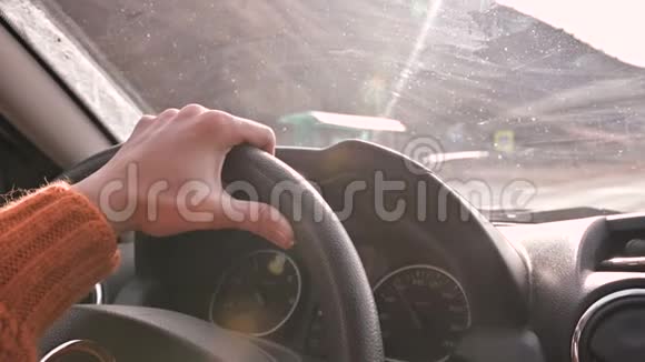 一只穿着橙色毛衣的雌性手在城外开着一辆车开车的女人视频的预览图