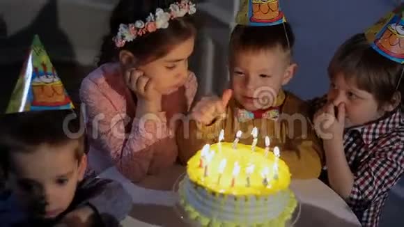 孩子们庆祝生日聚会在蛋糕的背景下交谈视频的预览图