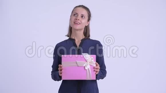 快乐年轻美丽的女商人拿着礼品盒思考视频的预览图