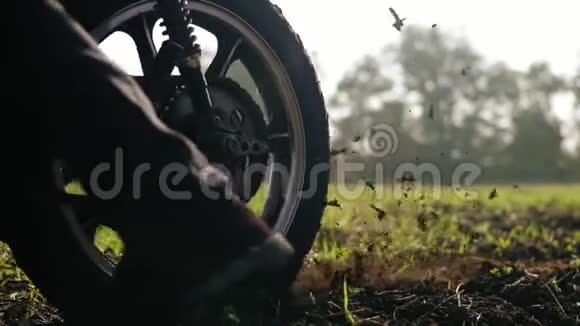 摩托车车轮开始旋转和踢地面或污垢摩托车开始运动慢动作视频的预览图