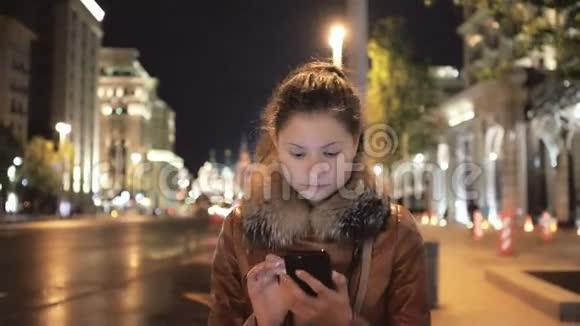 快乐女孩走路和使用移动智能手机视频的预览图