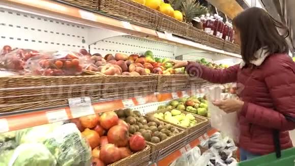 超市里的女人挑选水果和蔬菜视频的预览图