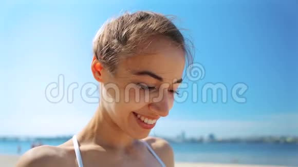 城市沙滩上美丽性感快乐女孩的肖像海蓝相间的背景视频的预览图