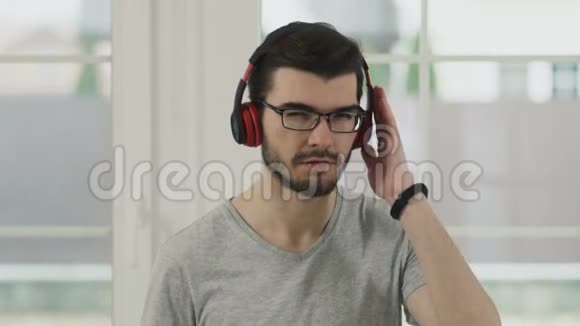 留胡子的年轻人用耳机听音乐慢动作视频的预览图