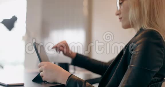 有魅力的年轻女性在家里使用数字平板电脑视频的预览图