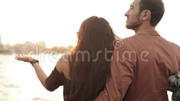 年轻夫妇在游船甲板上欣赏日落视频的预览图