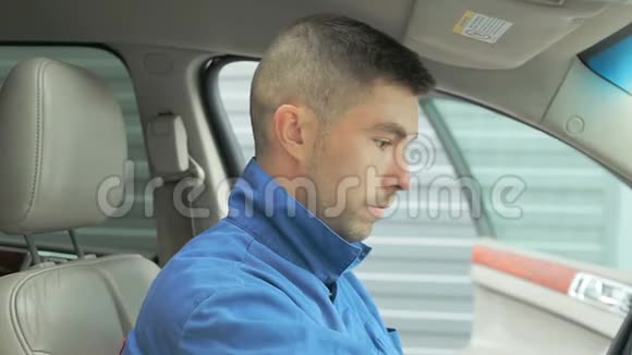 一名身穿工作服的修理工在车里检查变速箱和仪表盘视频的预览图