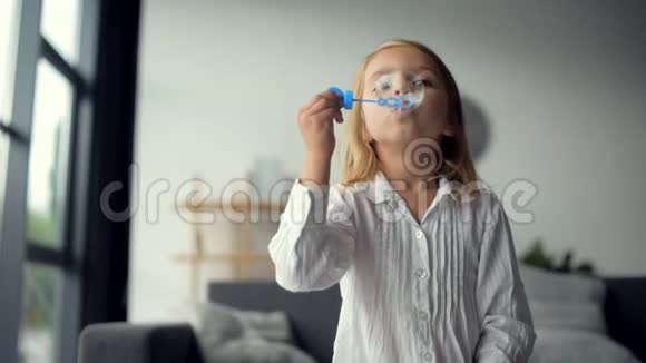 可爱积极的小女孩吹肥皂泡视频的预览图
