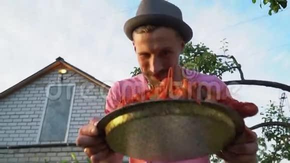 一个男人正在供应一盘煮小龙虾视频的预览图