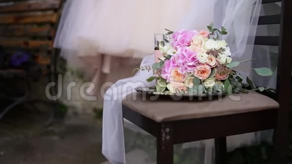 桌子上漂亮的新娘花束背景上有漂亮的婚纱和新娘配饰婚礼视频的预览图
