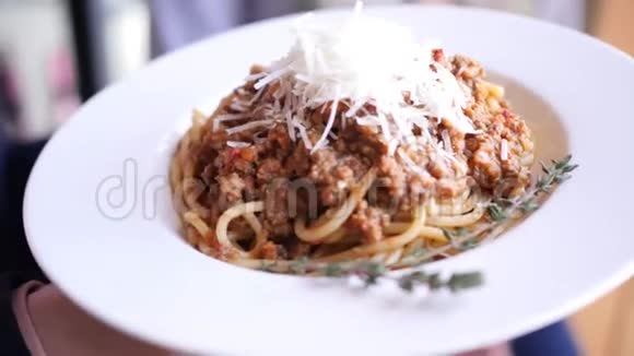 用迷迭香4K慢速相机运动装饰的盘子上放着帕尔马干酪的博洛尼亚面食视频的预览图