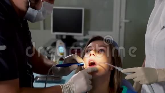 牙科诊所的医学牙科手术男性医生和助理视频的预览图