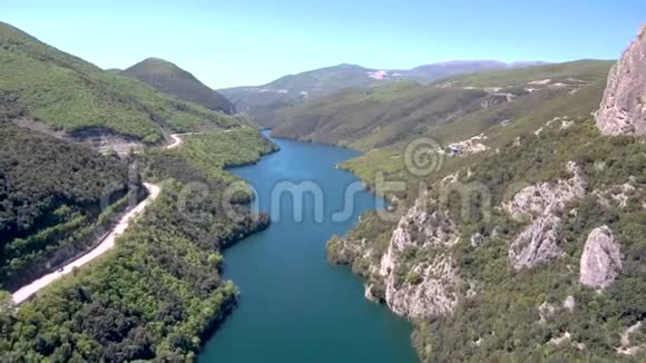 在山谷和乡村道路的侧面鸟瞰河流维里亚希腊视频的预览图