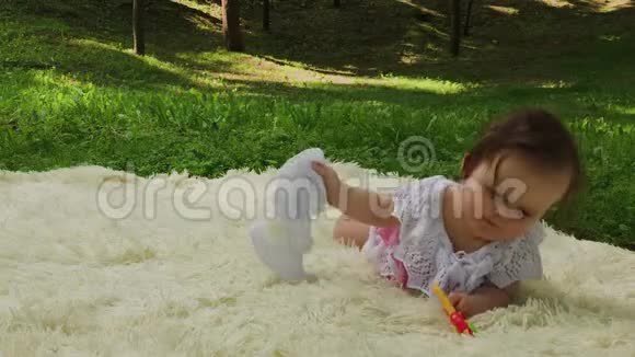 公园里一个很小很漂亮的女孩在床单上玩耍视频的预览图