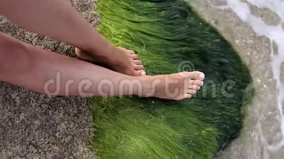 一个女孩在海边的石头上的腿视频的预览图