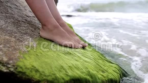 一个女孩在海边的石头上的腿视频的预览图