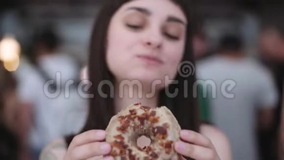 布鲁内特女孩咬了一个美味的甜甜圈视频的预览图
