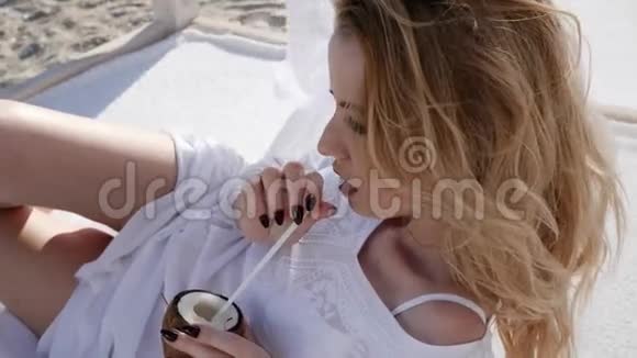 躺在平房上的女孩躺在海滩上白色窗帘上的阳光视频的预览图