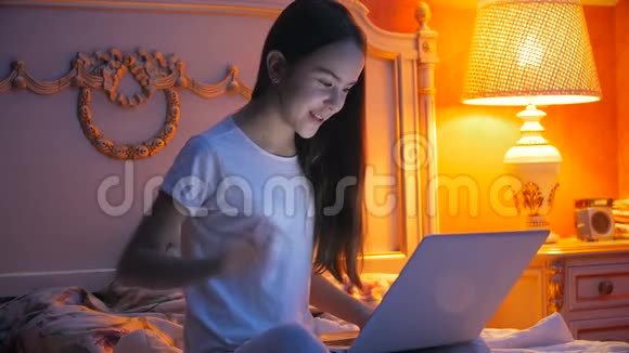 年轻女孩在笔记本电脑上进行视频谈话并向朋友挥手的4K镜头视频的预览图