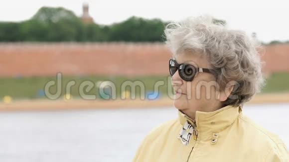 80岁的老妇人戴着深色眼镜看着对方视频的预览图