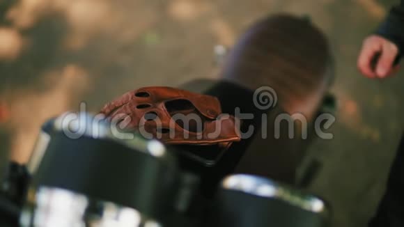 不可辨认的摩托车手来到他的摩托车前带着棕色的皮手套戴着特殊的皮手套视频的预览图
