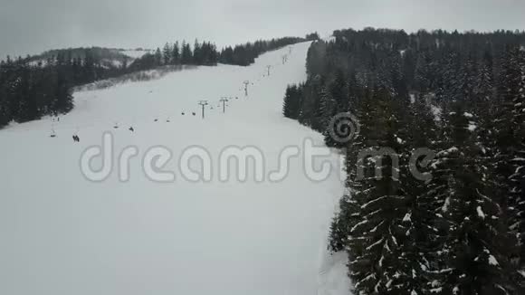乘坐喀尔巴阡山滑雪缆车空中俯瞰人们在滑雪板上下降视频的预览图
