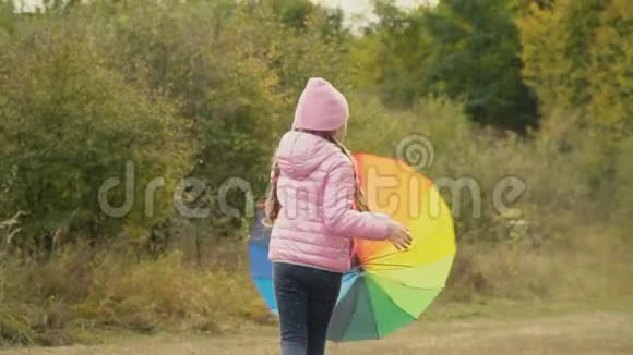 小女孩在玩一把五颜六色的伞视频的预览图