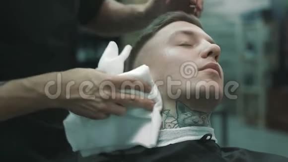 理发师用餐巾擦去客户的脸视频的预览图