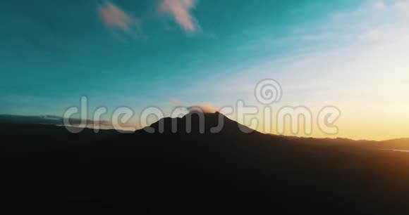 巴厘岛巴图尔火山轮廓的明亮日出空中全景视频的预览图