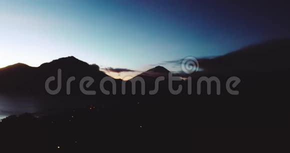 巴厘岛巴图尔火山轮廓的明亮日出空中全景视频的预览图