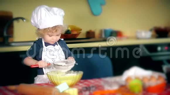 可爱的厨房厨师女孩把面粉筛成蛋糕视频的预览图