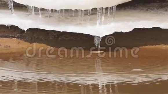 阳光明媚的一天冰柱在水面上融化视频的预览图