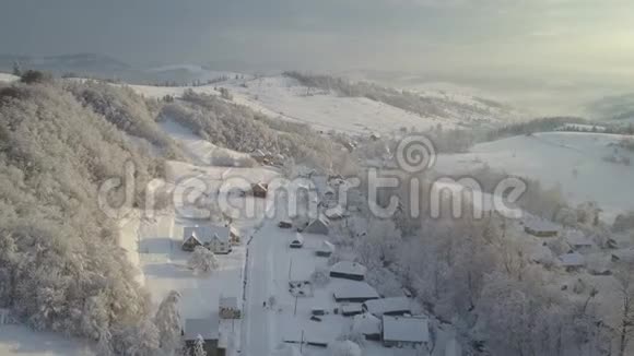 山村里的雪从一个高度日出时飞越喀尔巴阡山的一个村庄空中飞行视频的预览图