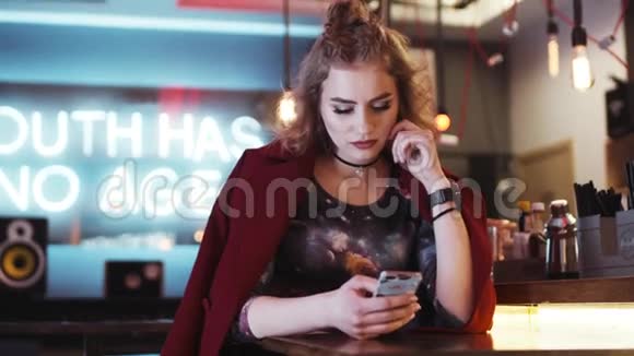时尚时髦的女孩红唇在一家舒适的咖啡馆里用手机收到信息看起来很失望短信回来了视频的预览图