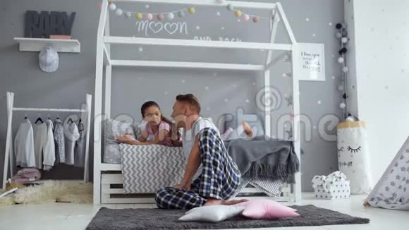 可爱的小女孩和她父亲一起做家庭作业视频的预览图