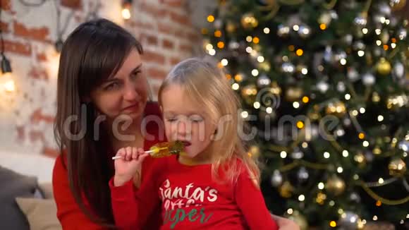 圣诞树旁的小女孩和妈妈视频的预览图